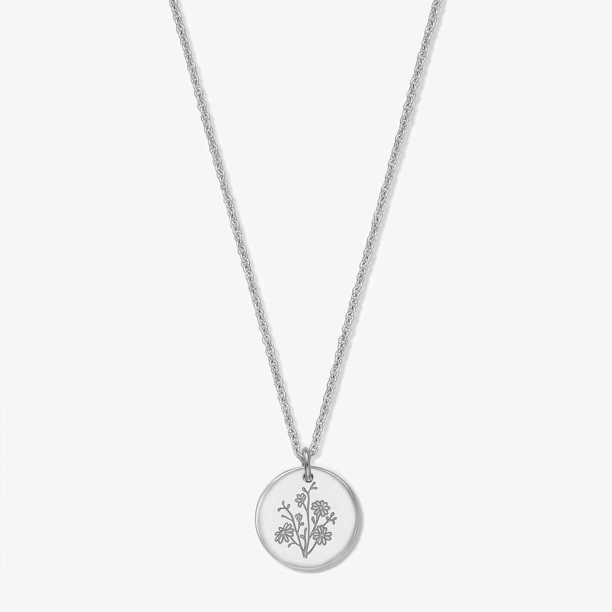 Birth flower silver necklace with a September aster–engraved round pendant in 925 silver on a delicate chain, isolated on a white background.