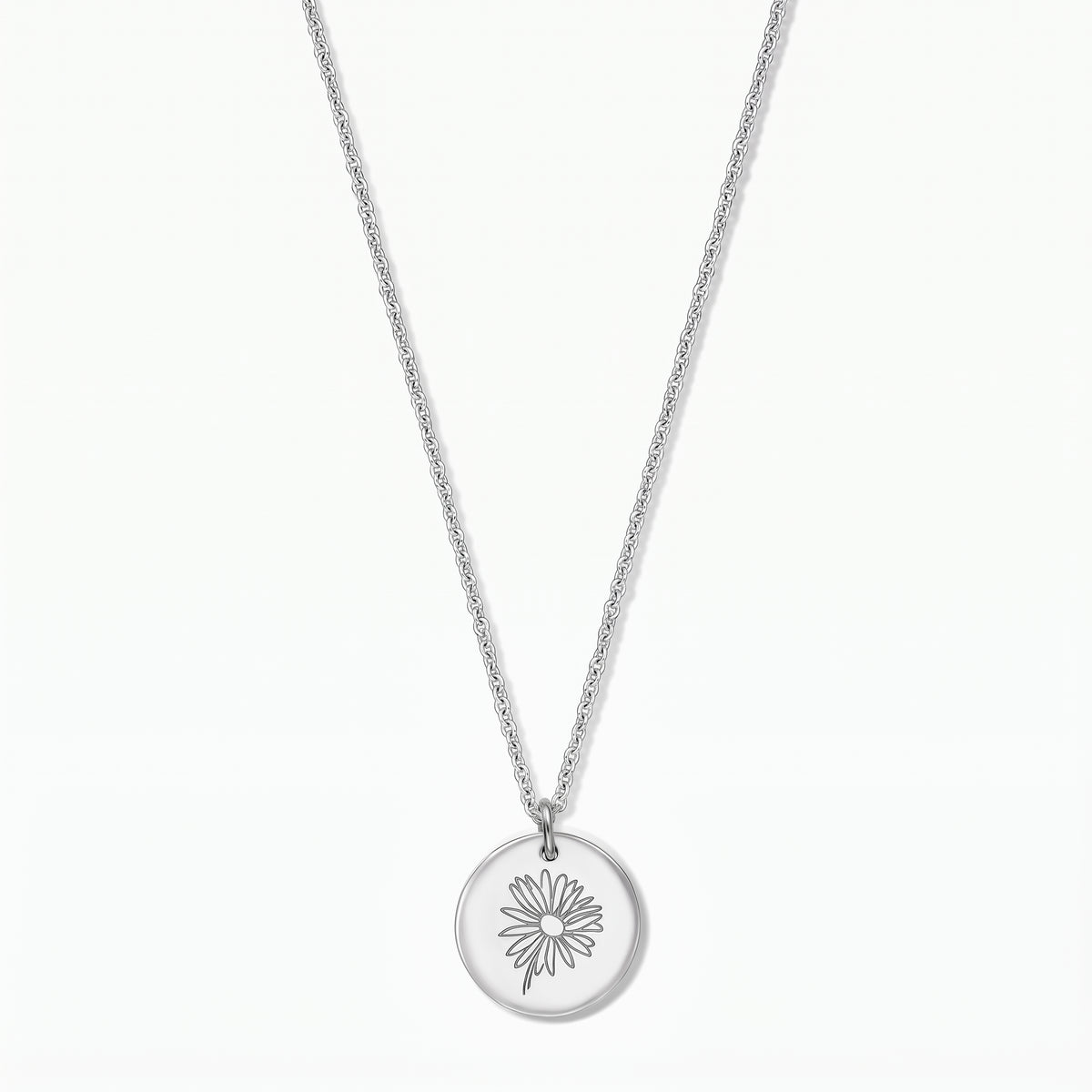 Elegant sterling silver necklace featuring a round disc pendant engraved with a daisy, photographed on a white background.