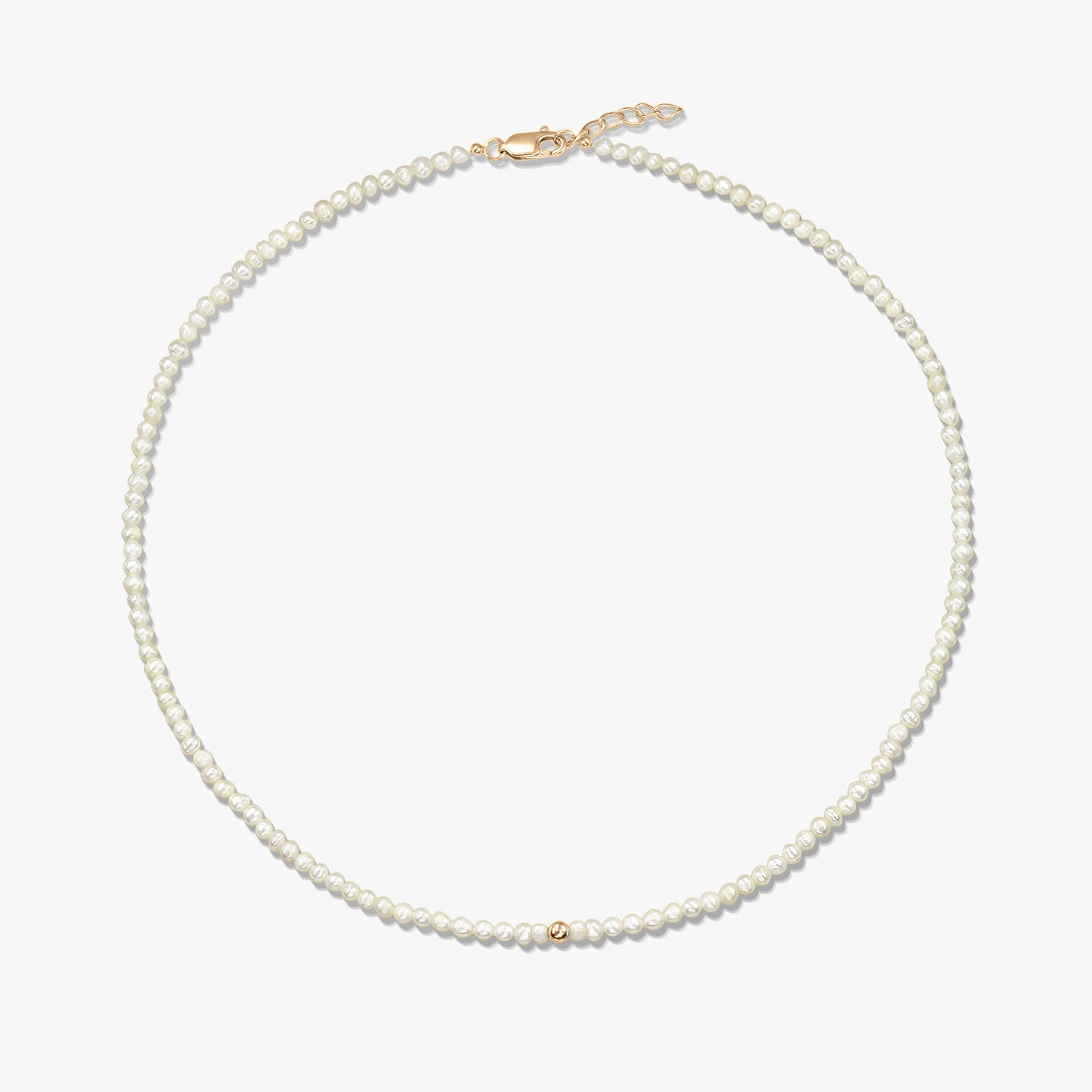 Square product photo of a delicate natural pearl beaded necklace featuring a small 14K yellow gold accent bead and a yellow-gold lobster clasp with a short extender, on a white background.