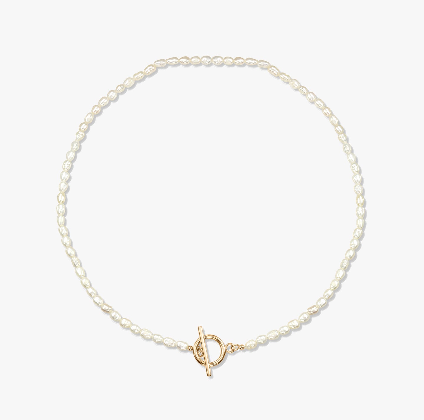 A minimalist pearl necklace with a gold toggle clasp on a white background.