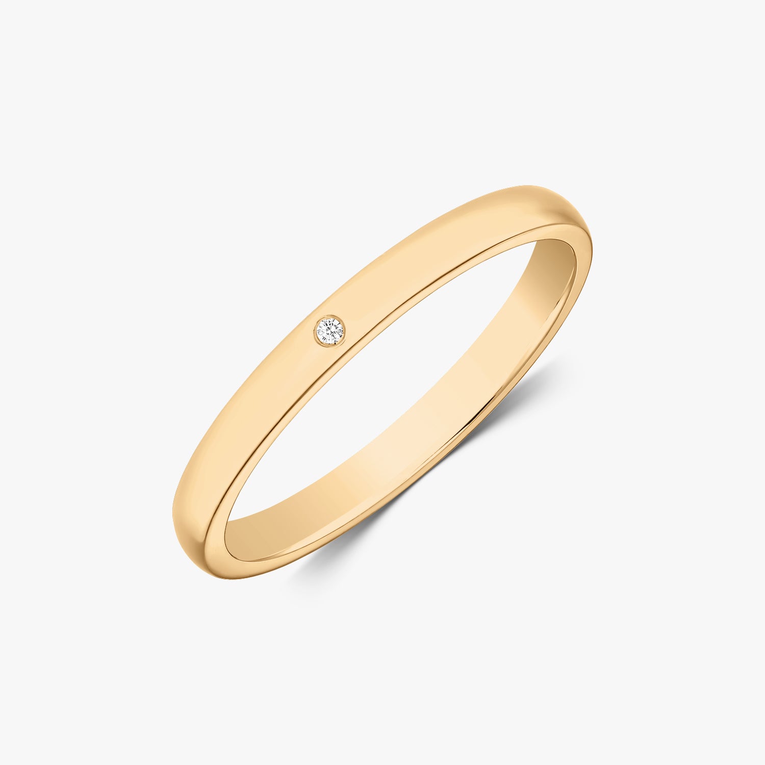 Elegant slim gold wedding band with a small diamond on a white background.