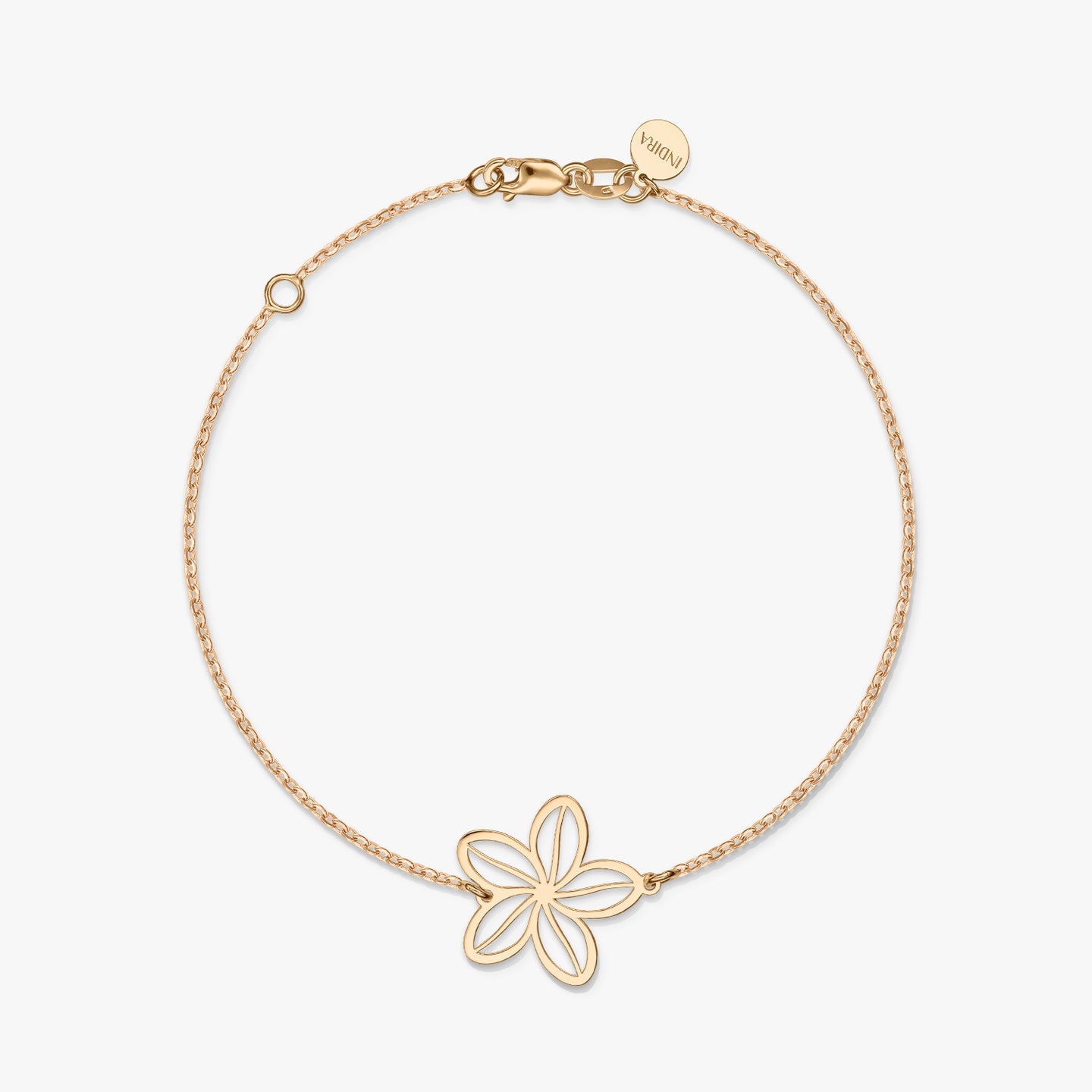 A minimalist gold bracelet with a delicate flower charm on a solid white background.