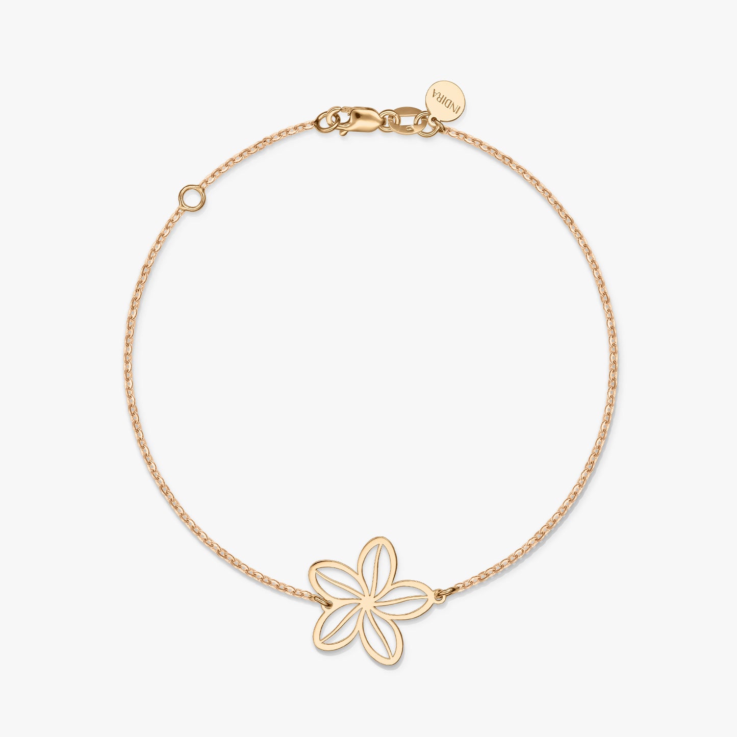 A minimalist gold bracelet with a delicate flower charm on a solid white background.