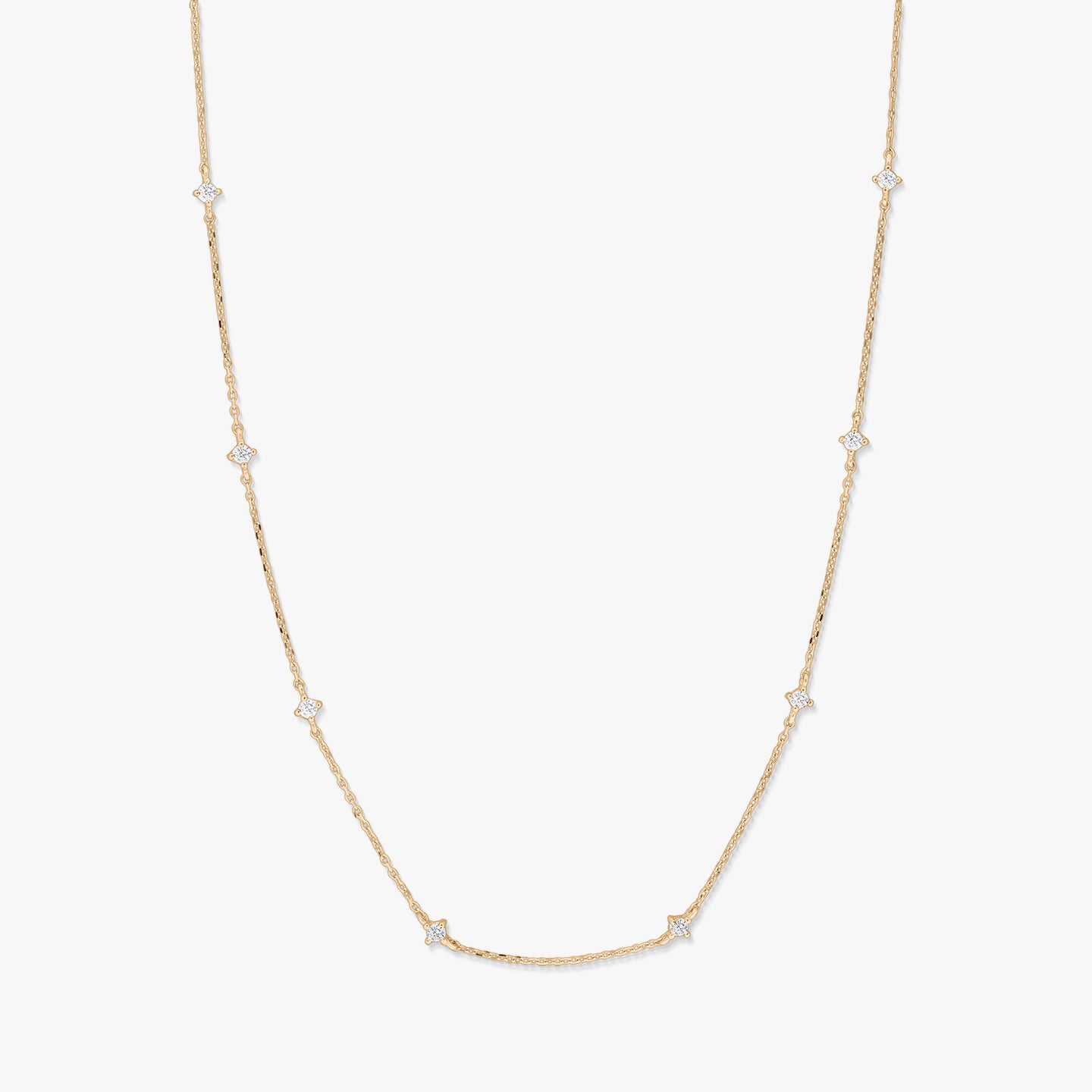Delicate 14K yellow gold station necklace featuring small starburst-shaped white zirconia accents spaced along a fine chain, photographed on a white background.