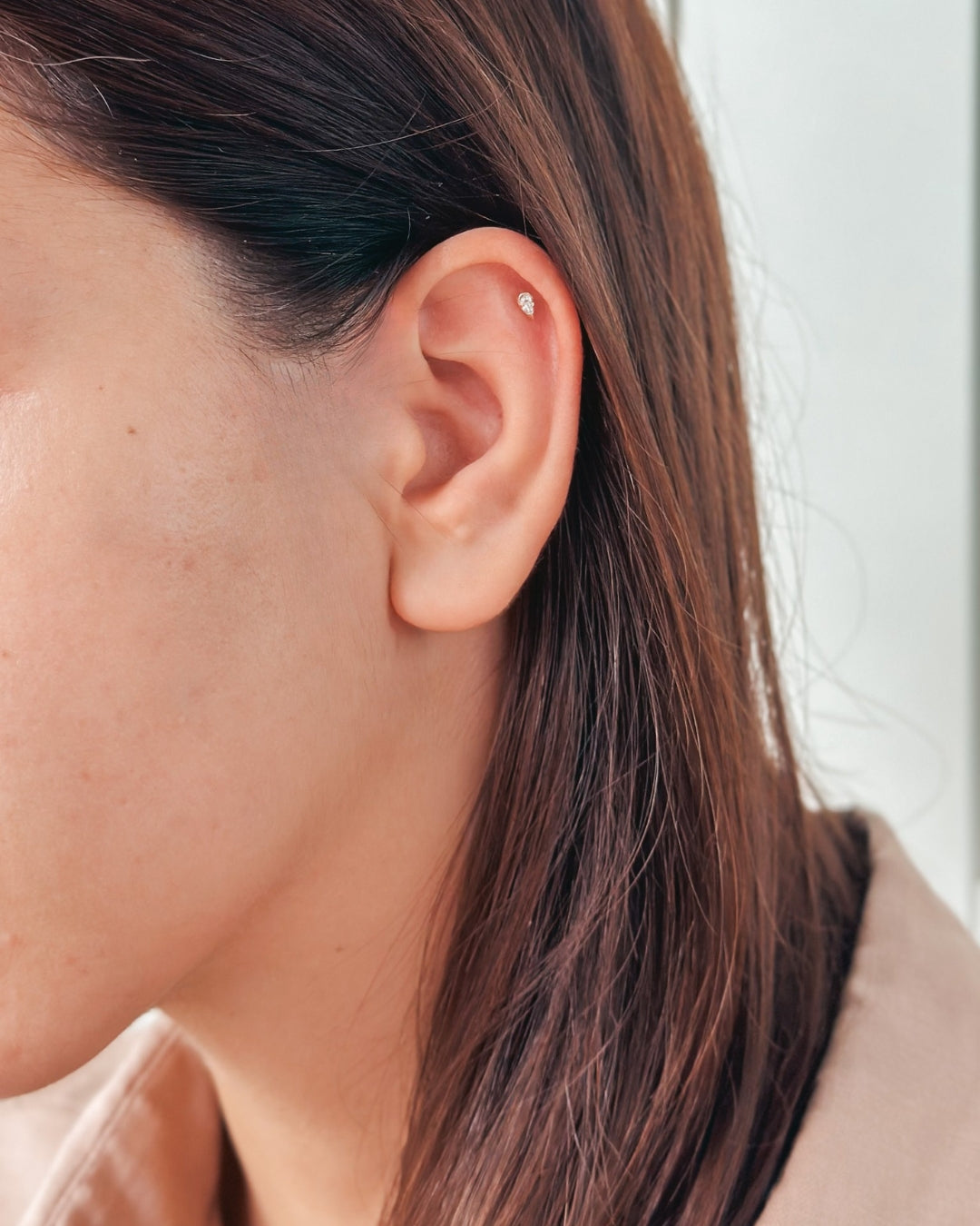 Close-up of an ear featuring a small stud earring