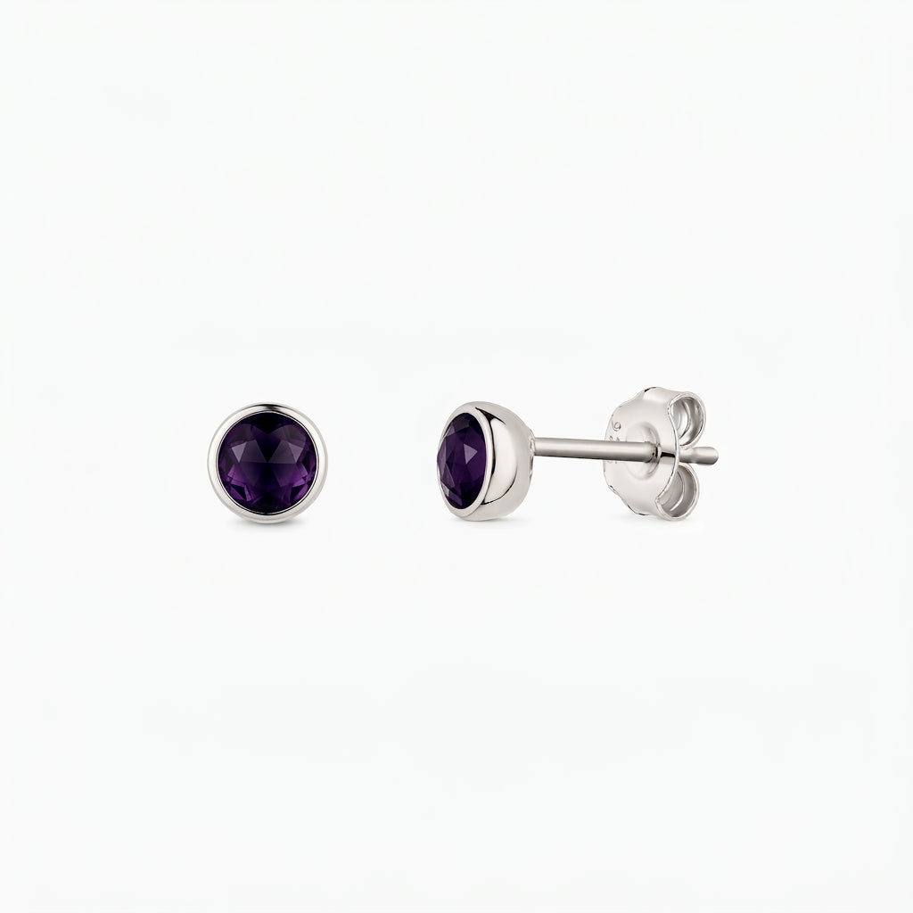 Pair of sterling silver stud earrings featuring round, faceted amethyst stones in bezel settings, shown from the front and side on a white background.