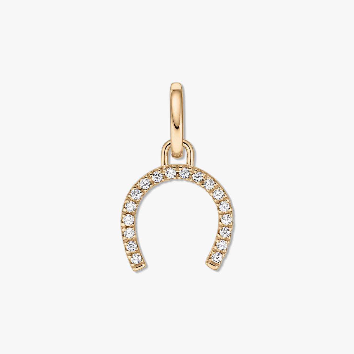 Silver horseshoe pendant in gold tone adorned with pavé clear zirconia stones on a white background.