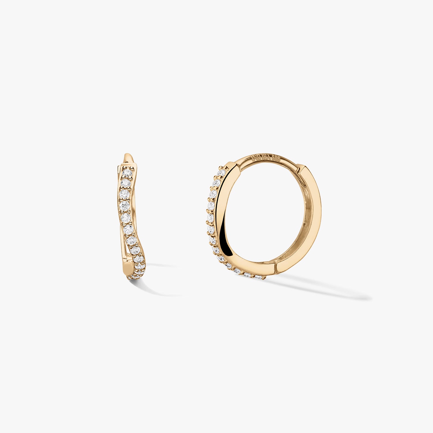 Pair of 14k yellow gold huggie hoop earrings with a wavy pavé row of white zirconia, shown on a clean white background—one side view and one open hoop to show the closure.