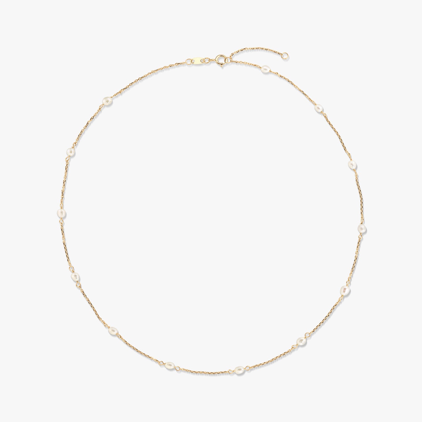 14K yellow gold station necklace with small natural white pearls spaced along a delicate chain, isolated on a white background.