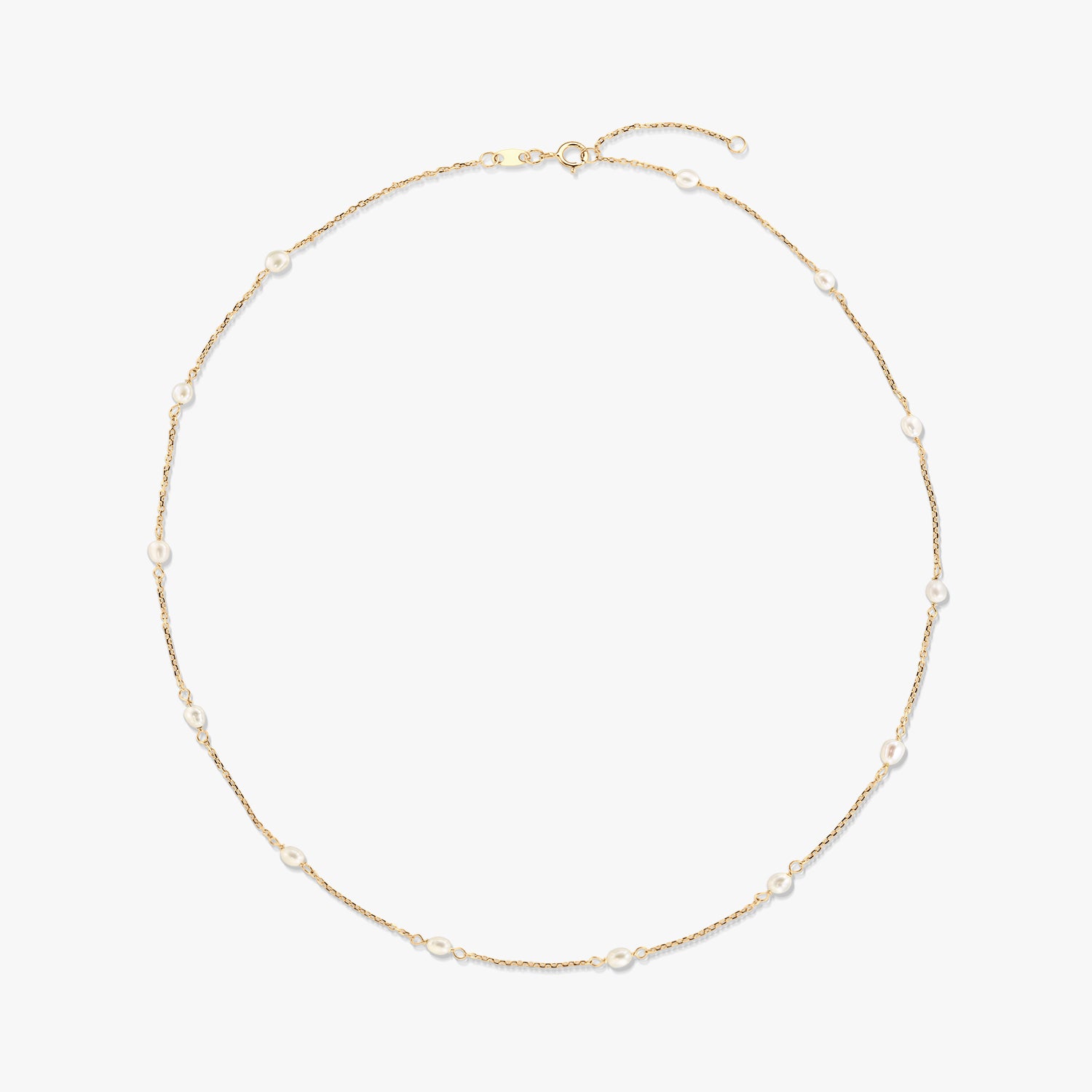 14K yellow gold station necklace with small natural white pearls spaced along a delicate chain, isolated on a white background.