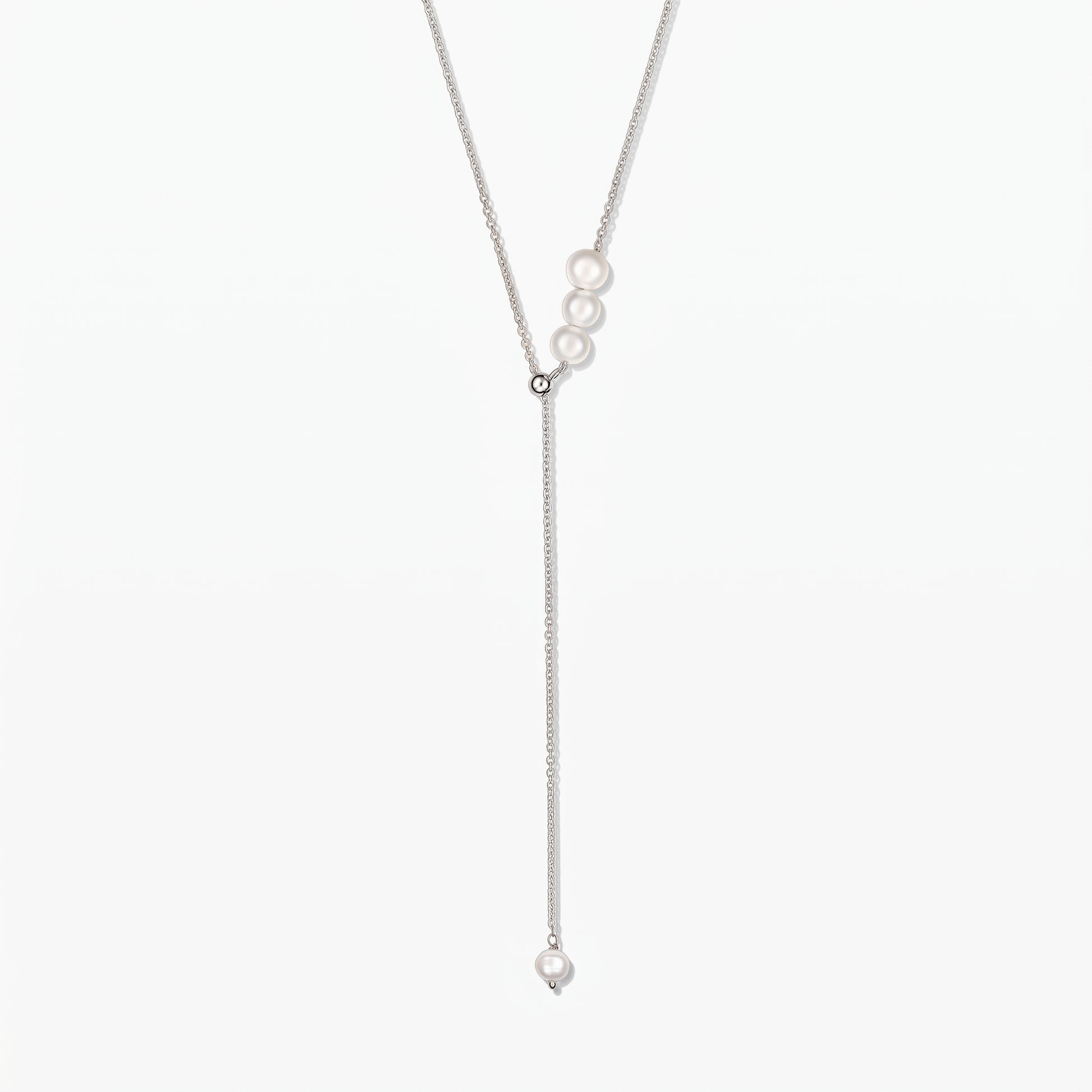Elegant adjustable sterling silver lariat necklace with white cultured pearls, against a white background.
