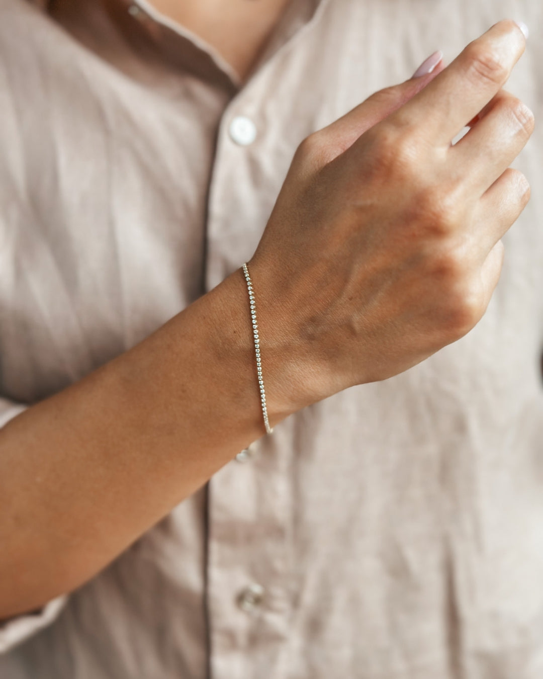 Close-up image of a hand adorned with a delicate, elegant bracelet