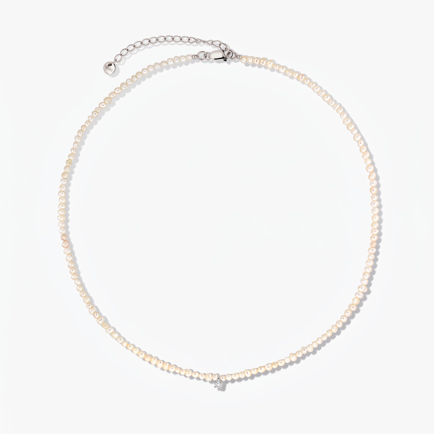 Fairy silver necklace with small cultured pearls and an adjustable extender chain, photographed on a white background.