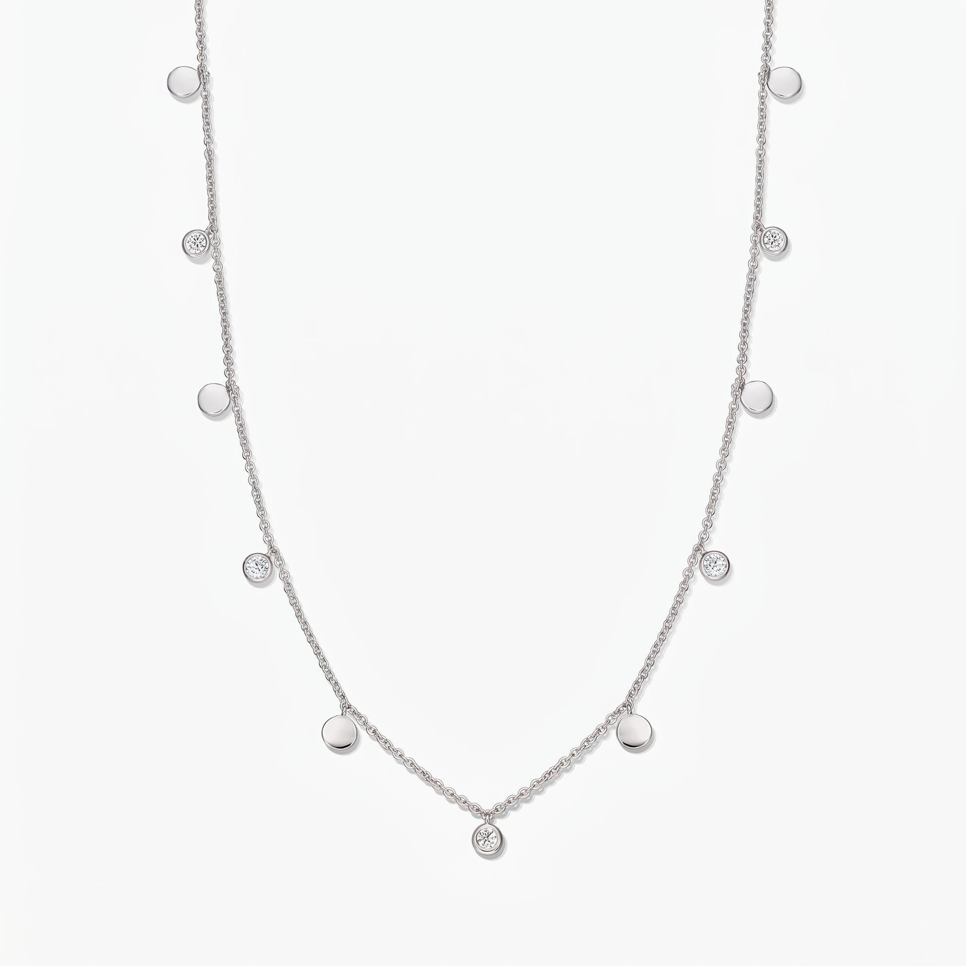 Sterling silver Noora station necklace with alternating polished discs and bezel‑set white topaz stones on a white background.