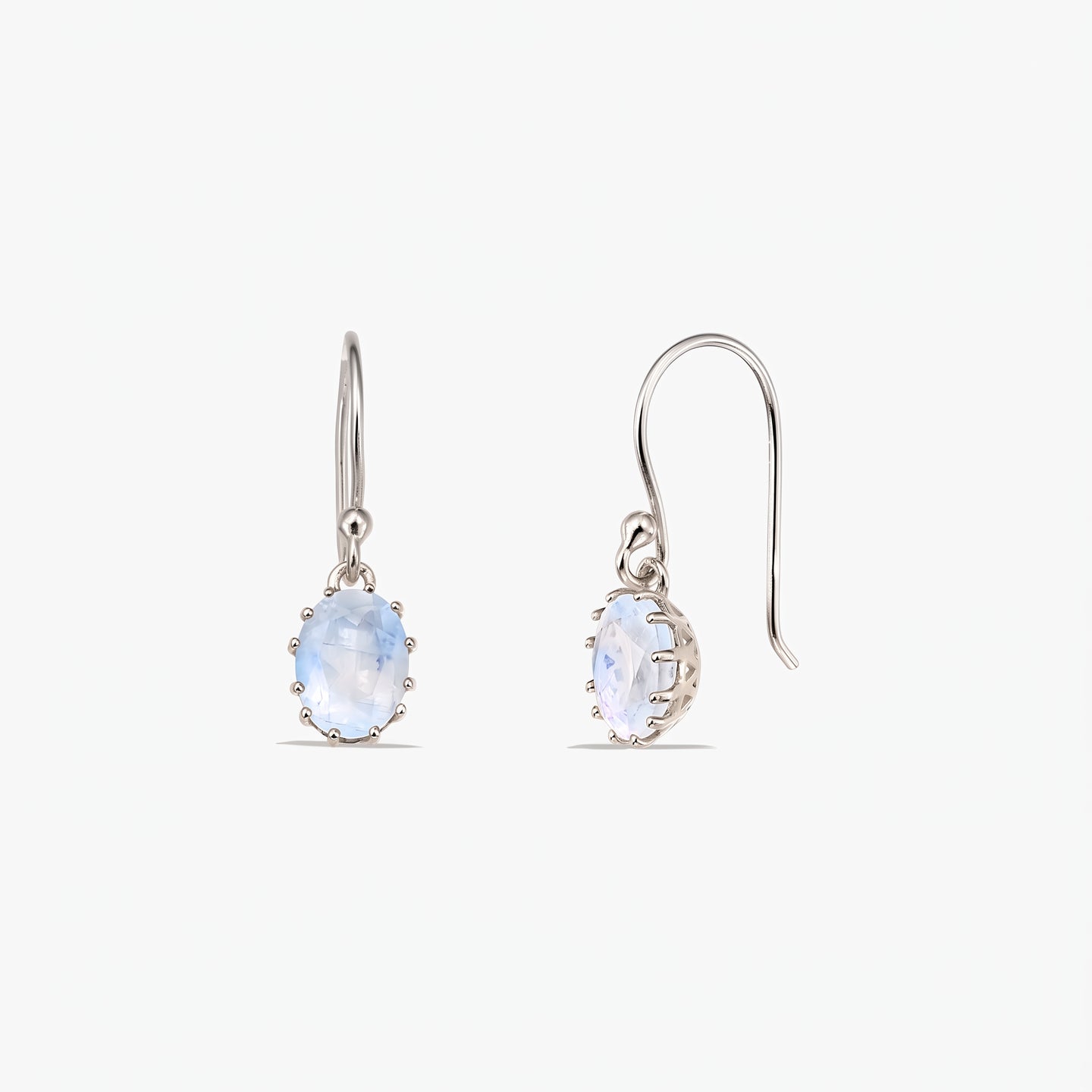 Pair of sterling silver drop earrings with oval faceted moonstones on French hooks, shown on a white background (front and side views).