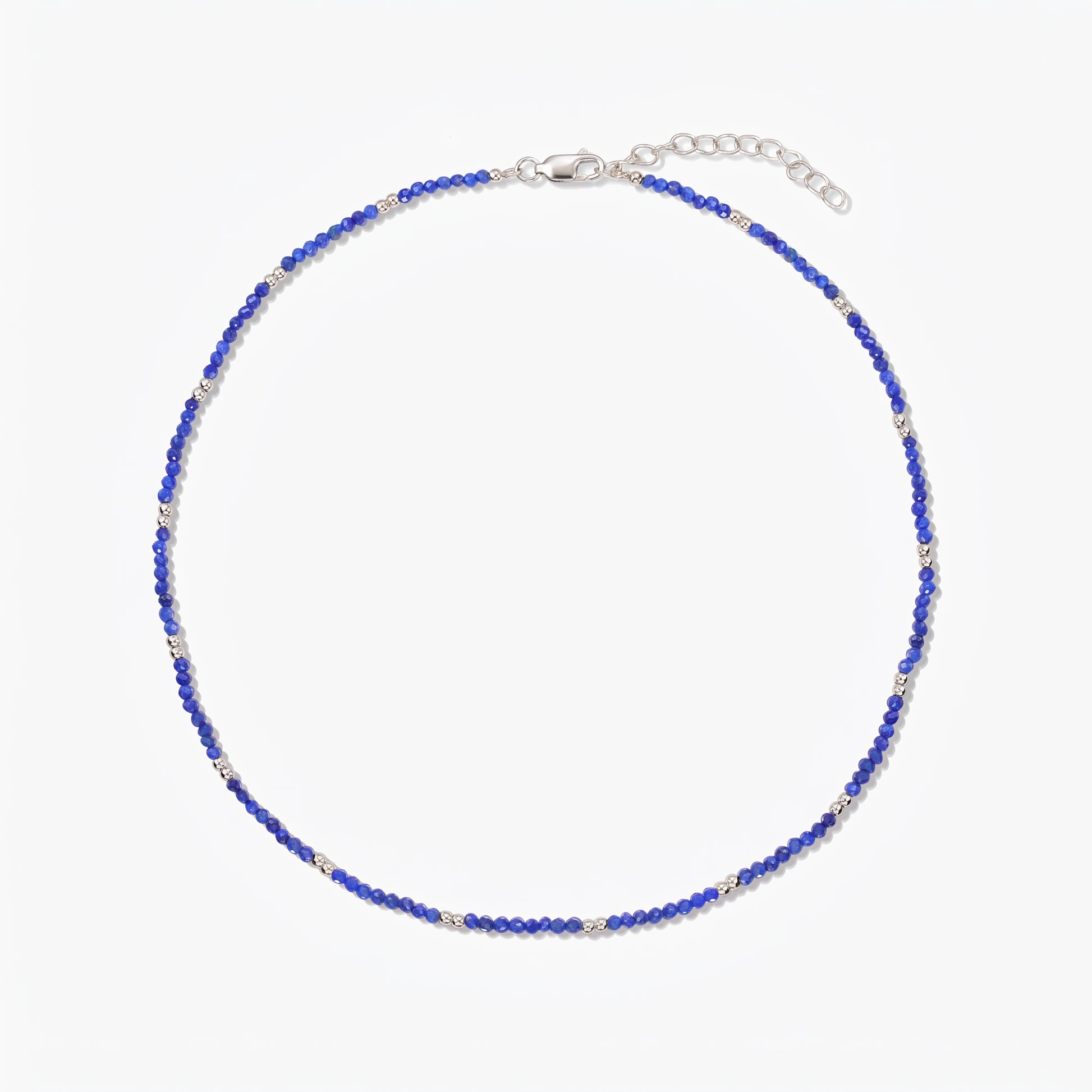 Indira SummerScape silver necklace with blue lapis lazuli beads, lobster clasp, and extender chain on a white background.