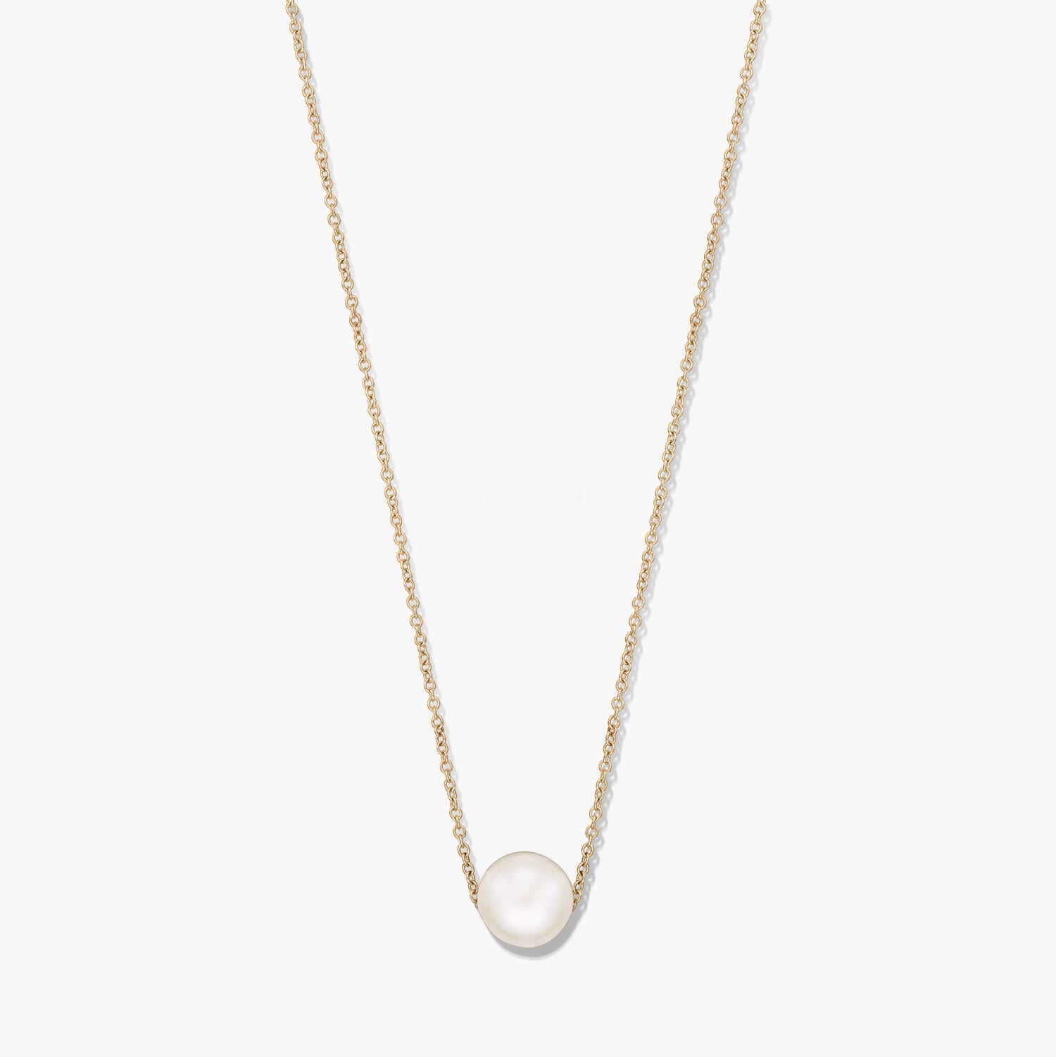 Elegant gold‑tone chain necklace featuring a single natural white pearl centered on the chain, isolated on a white background.