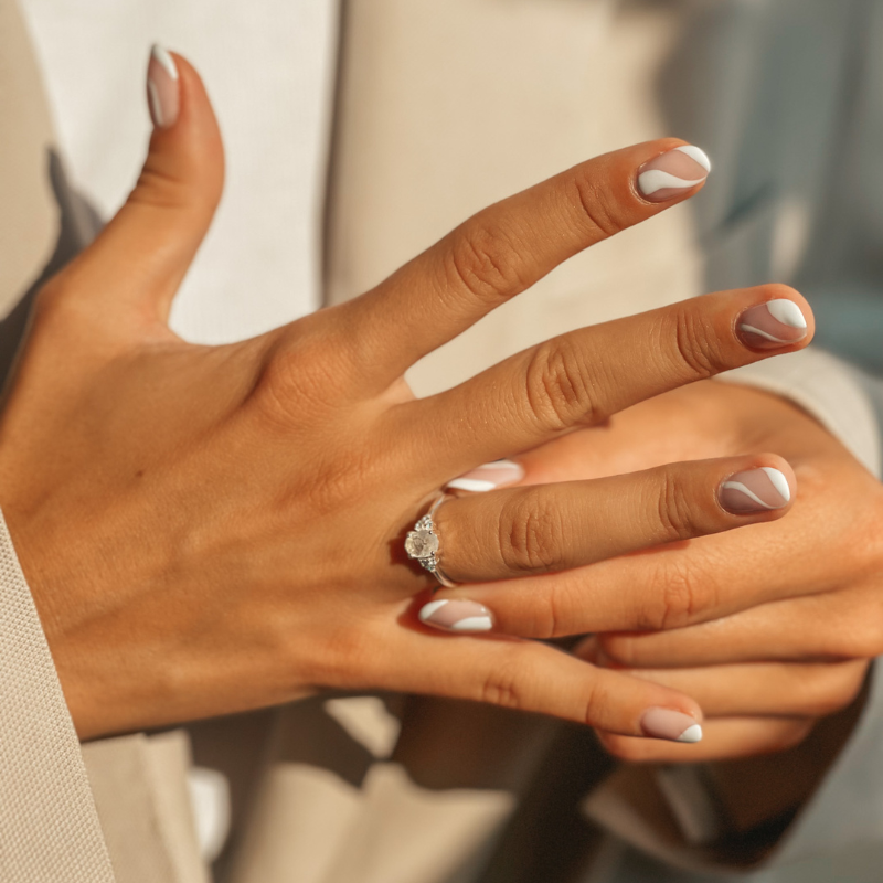 Close-up of a hand with a nail art manicure wearing a radiant silver ring with a moonstone.