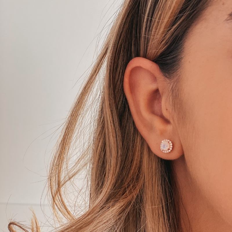 Close-up of a person's ear wearing a Keira Rose Silver Earring with Moonstone against a light background.