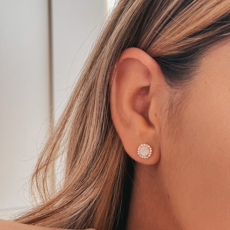 Close-up of a woman's ear adorned with a Keira Rose Silver Earring featuring a moonstone.