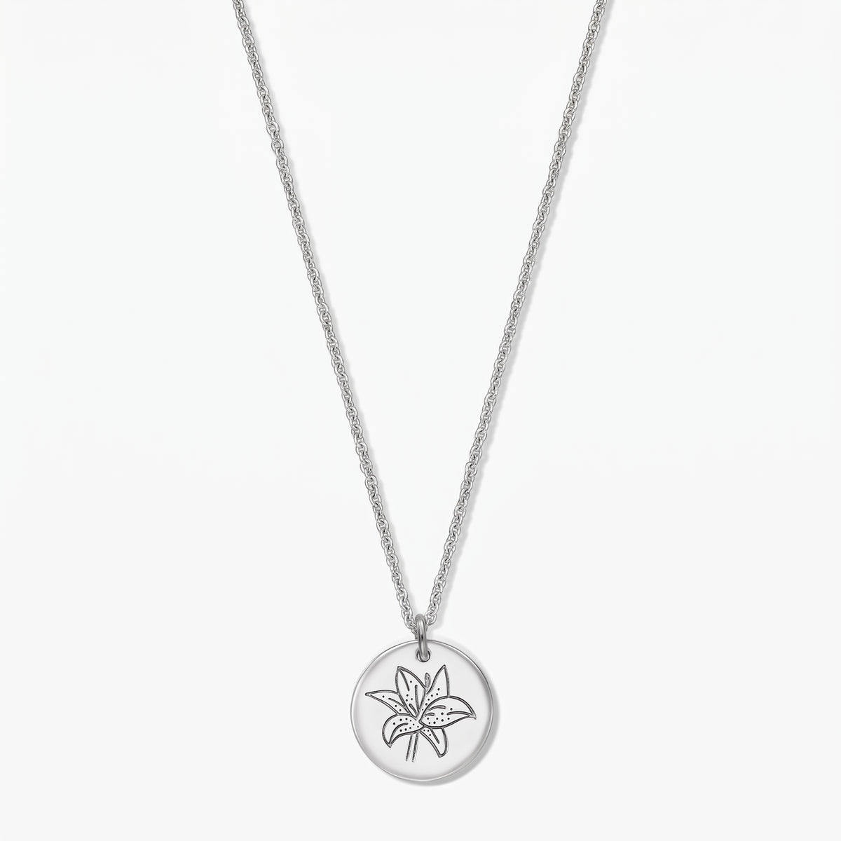 Sterling silver birth flower necklace featuring a round disc pendant engraved with a lily (May), shown on a white background.