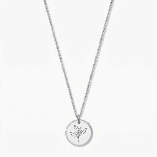 Elegant sterling silver birthflower necklace with a round pendant engraved with a holly sprig on a white background.