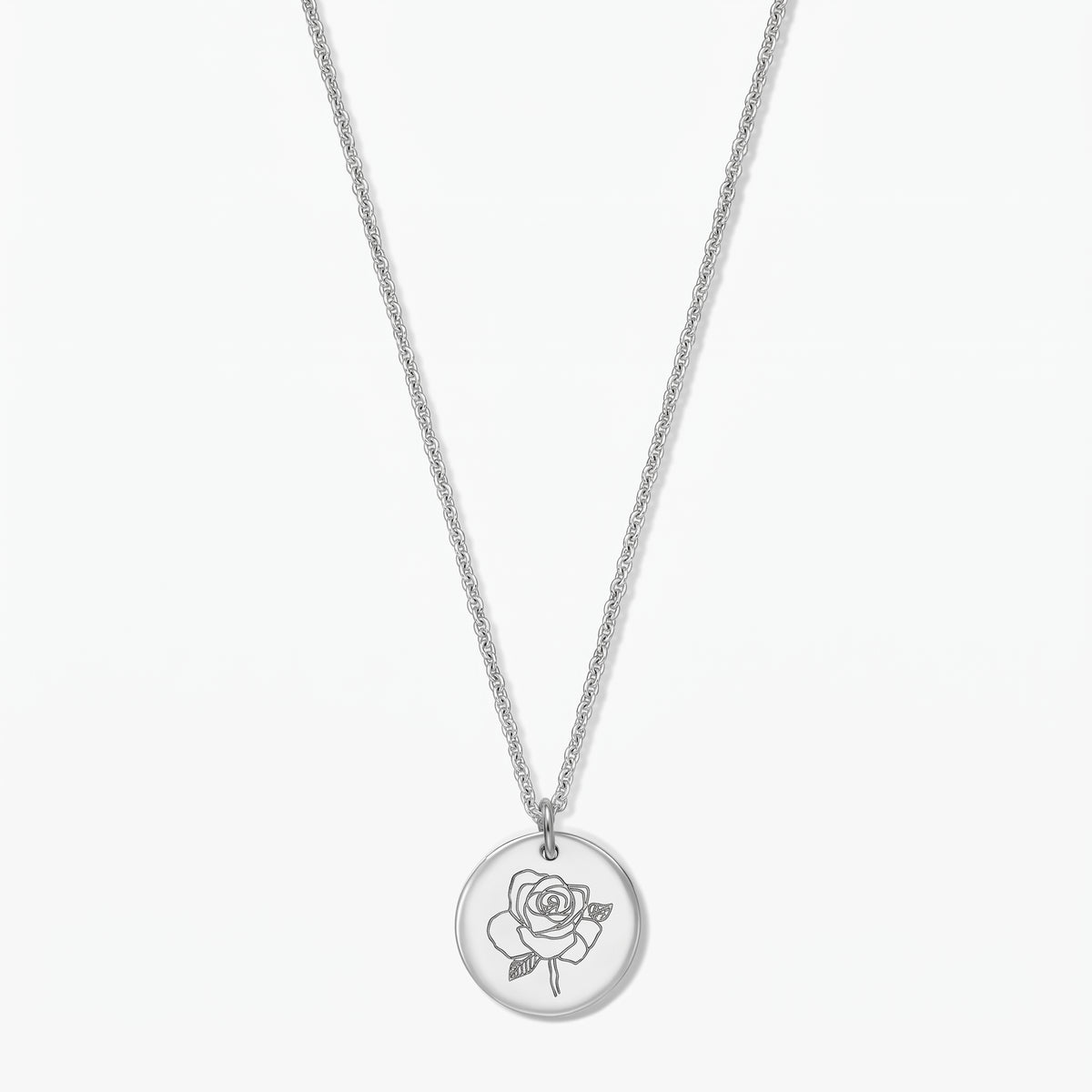 Elegant sterling silver birth flower necklace featuring a round pendant engraved with a rose (June), photographed on a white background.