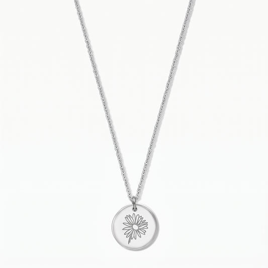 Elegant sterling silver necklace featuring a round disc pendant engraved with a daisy, photographed on a white background.