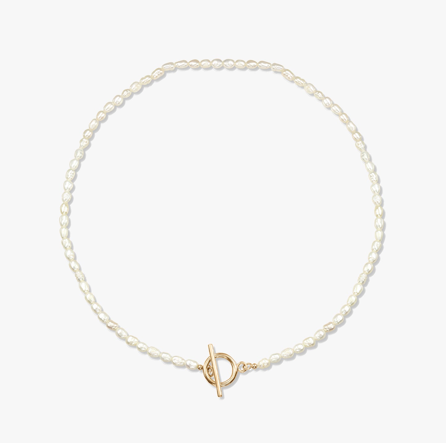 A minimalist pearl necklace with a gold toggle clasp on a white background.