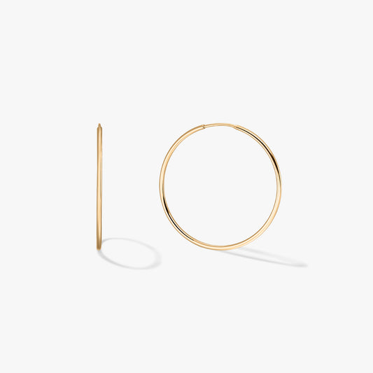 A pair of gold hoop earrings showcased on a white background.