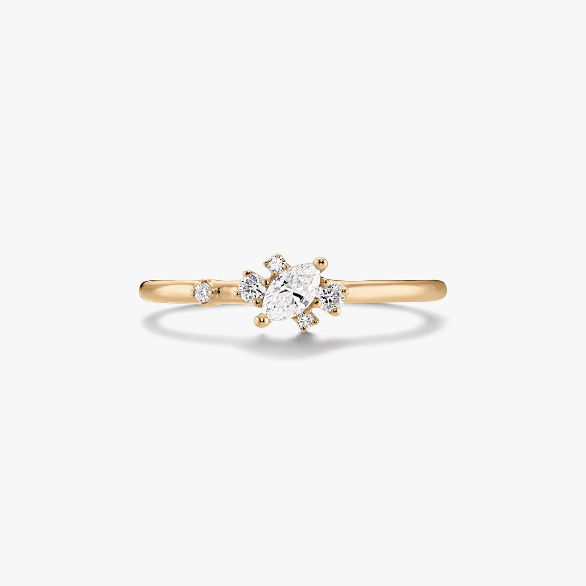 Thin 14K yellow gold ring with a marquise‑cut center diamond and small round accent diamonds on a white background.