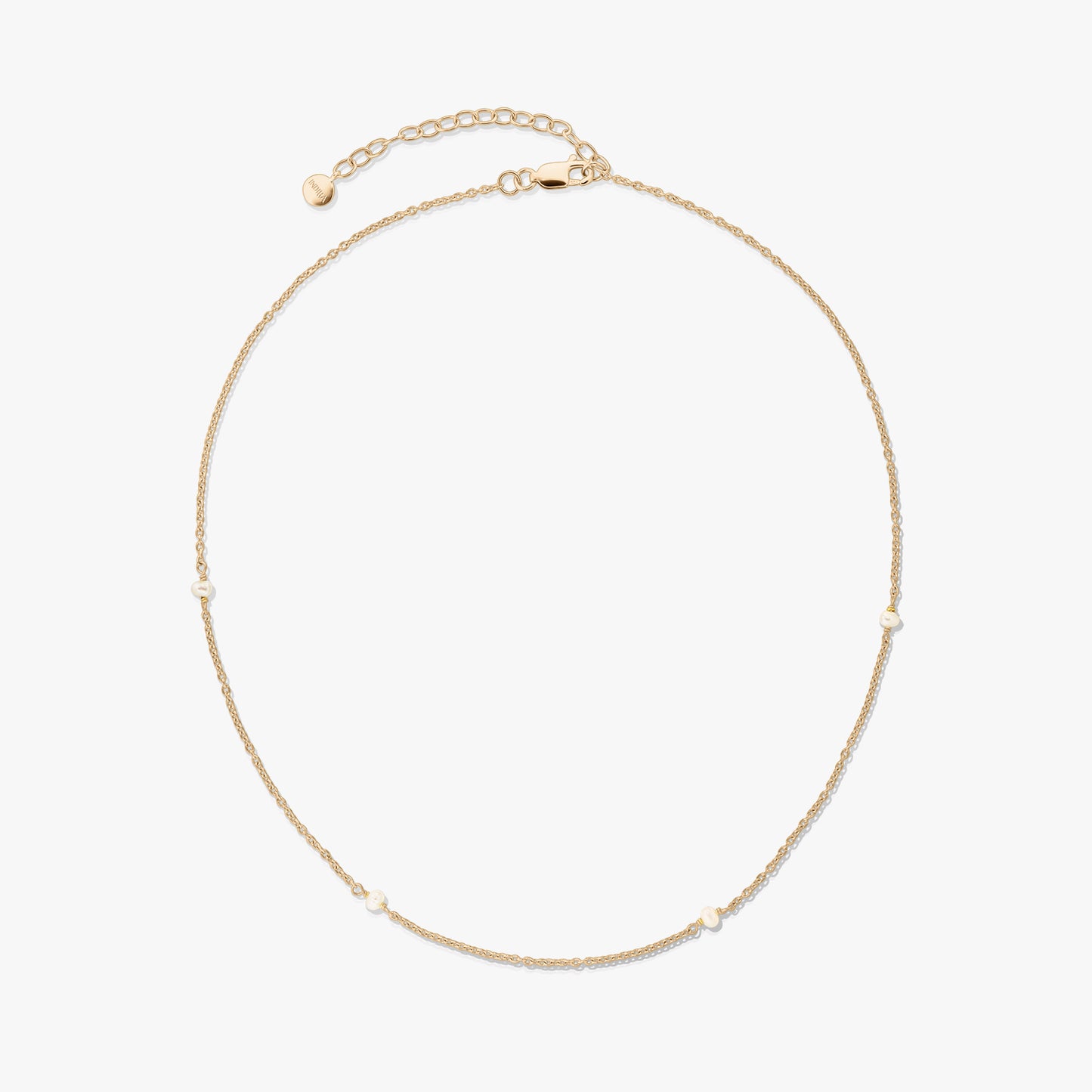 Delicate gold-plated 925 silver necklace with tiny natural pearls and an adjustable extender with a lobster clasp on a white background.