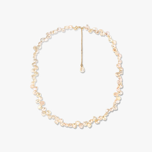 Gold-plated silver necklace with irregular pink keshi pearls and an adjustable extender, photographed on a white background.