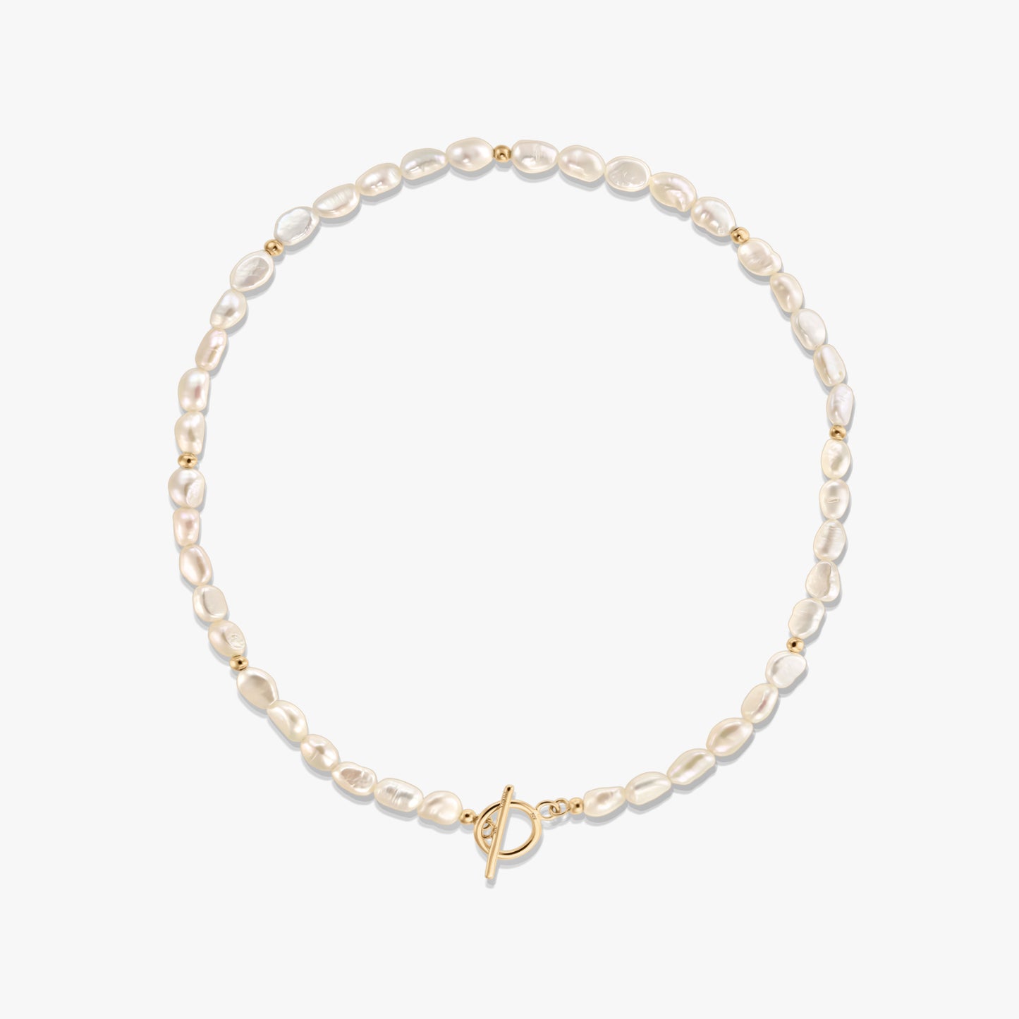 Studio photo of a natural pearl beaded necklace with small gold spacer beads and a gold-tone toggle clasp, arranged in a circle on a white background.