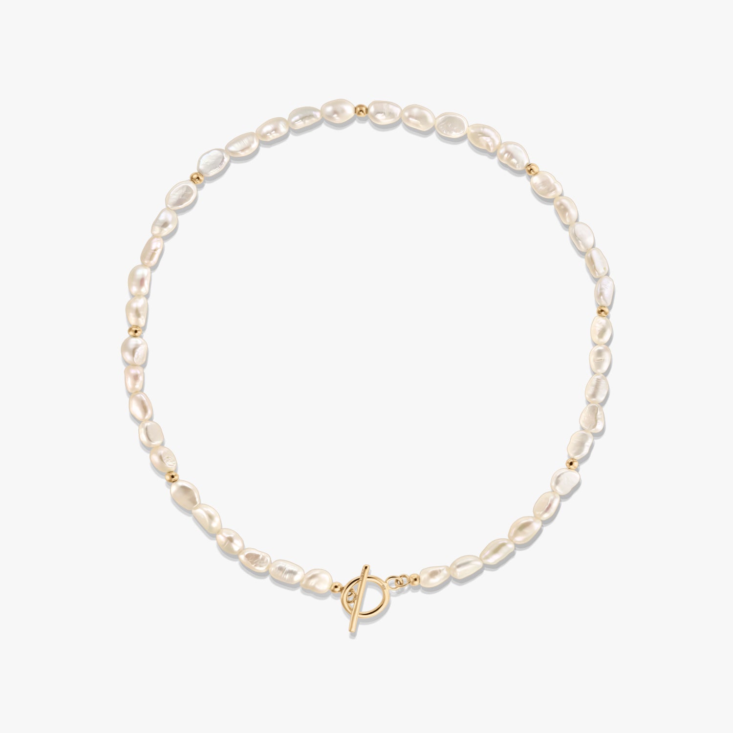 Studio photo of a natural pearl beaded necklace with small gold spacer beads and a gold-tone toggle clasp, arranged in a circle on a white background.