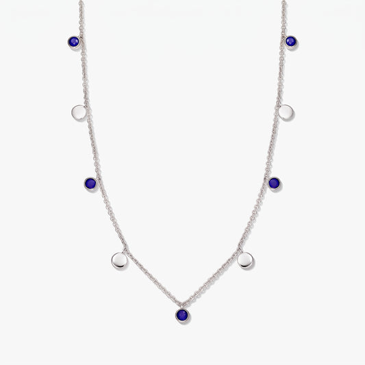 Sterling silver station necklace with round lapis lazuli cabochons and polished silver discs on a white background.