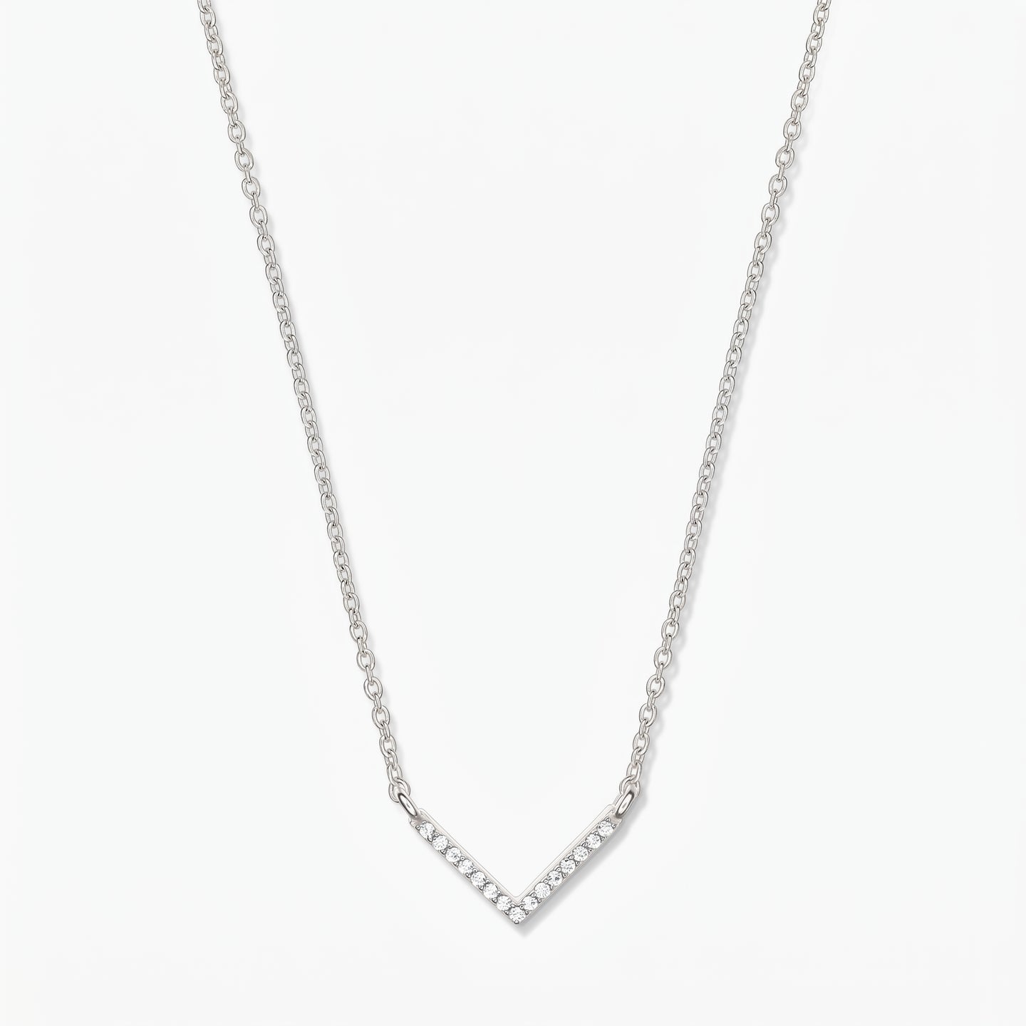 Silver V-shaped zirconia necklace with a delicate chain and pavé chevron pendant on a white background.