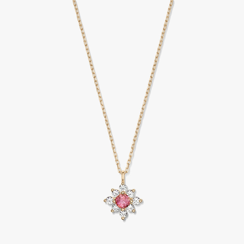 Elegant 14K gold necklace with a floral pendant featuring a pink tourmaline center haloed by white sapphires on a white background.