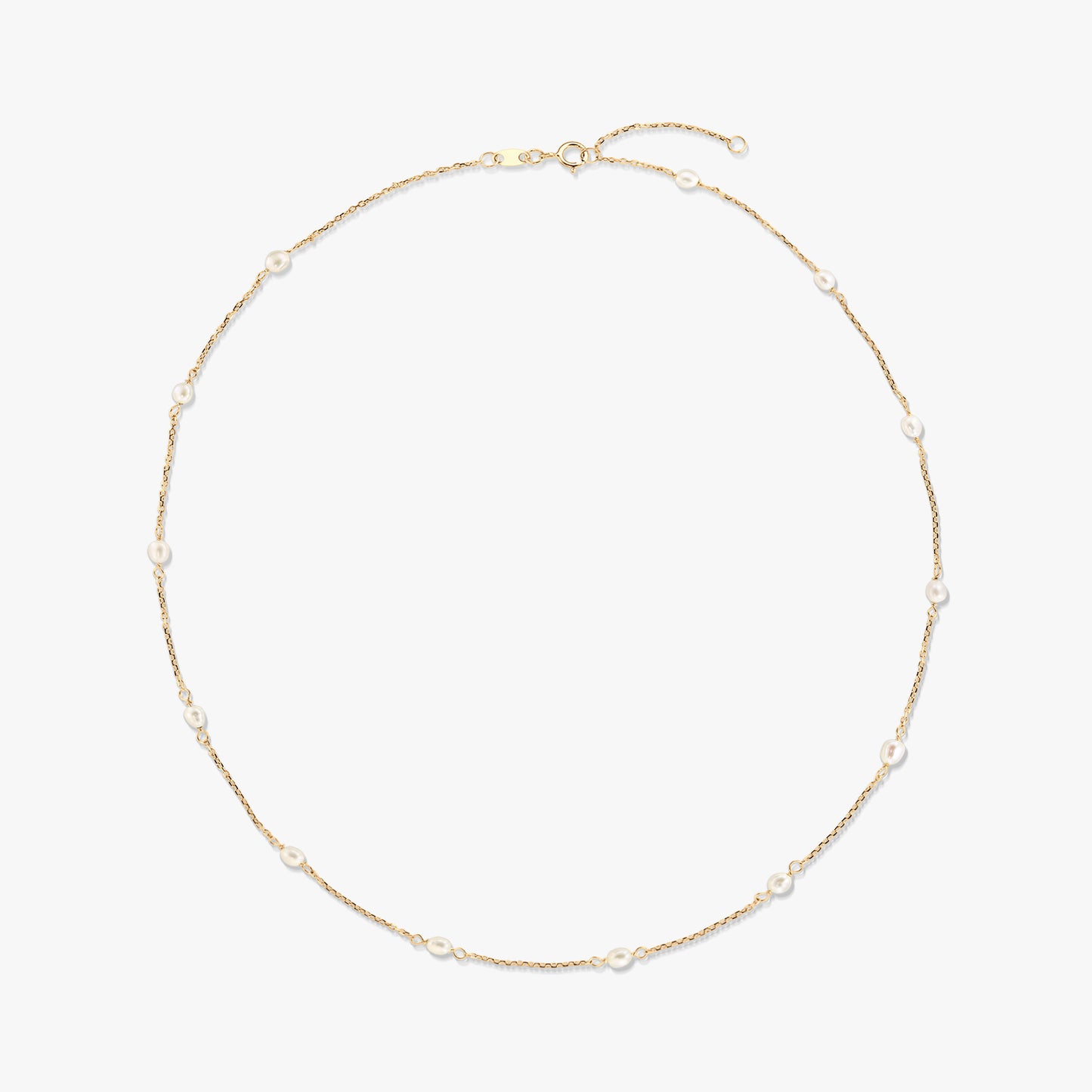 14K yellow gold station necklace with small natural white pearls spaced along a delicate chain, isolated on a white background.
