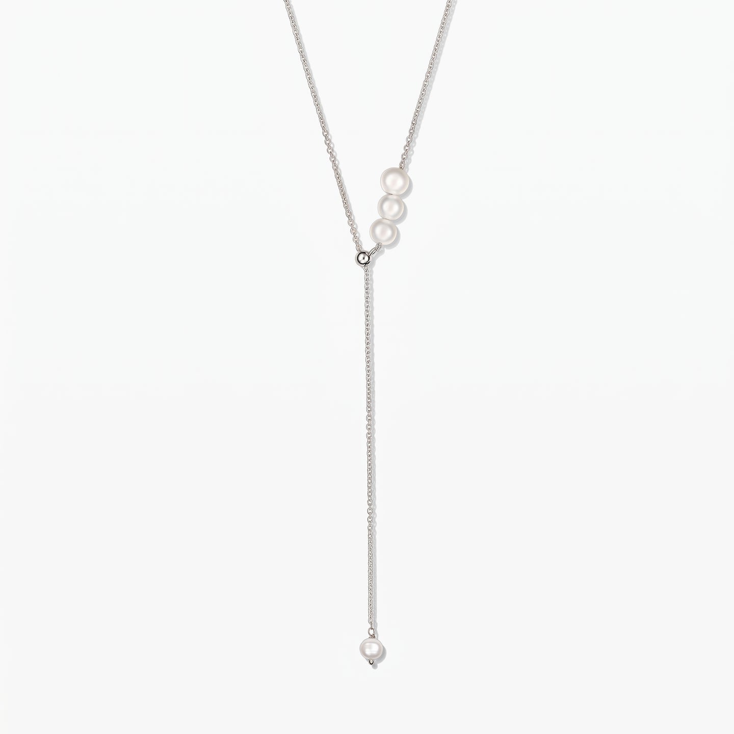 Elegant adjustable sterling silver lariat necklace with white cultured pearls, against a white background.