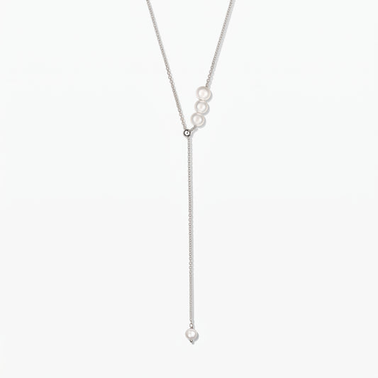Elegant adjustable sterling silver lariat necklace with white cultured pearls, against a white background.
