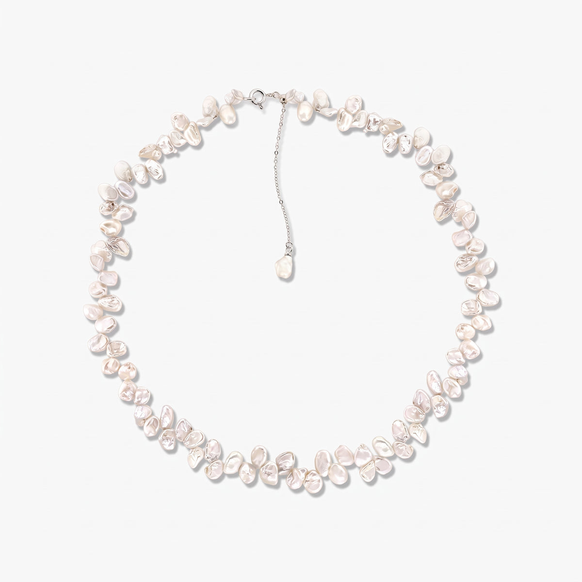 Sterling silver necklace featuring irregular baroque white cultured pearls arranged in a circle on a white background, with an adjustable chain and a dangling pearl charm.