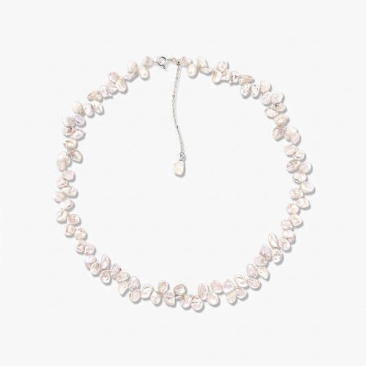 Sterling silver necklace featuring irregular baroque white cultured pearls arranged in a circle on a white background, with an adjustable chain and a dangling pearl charm.