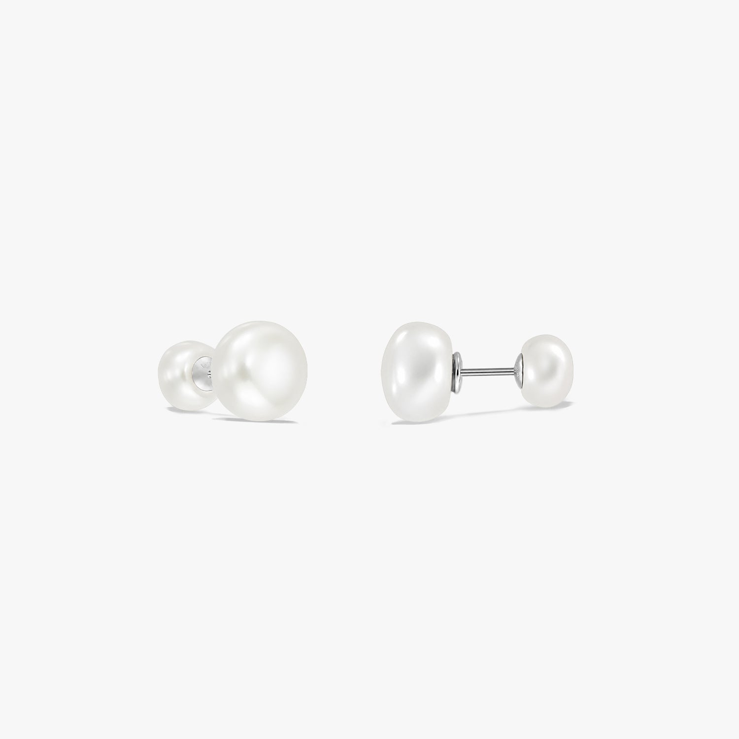 Elegant sterling silver double-pearl stud earrings on a white background, featuring a large natural white pearl on one end and a smaller pearl on the other, connected by a post.