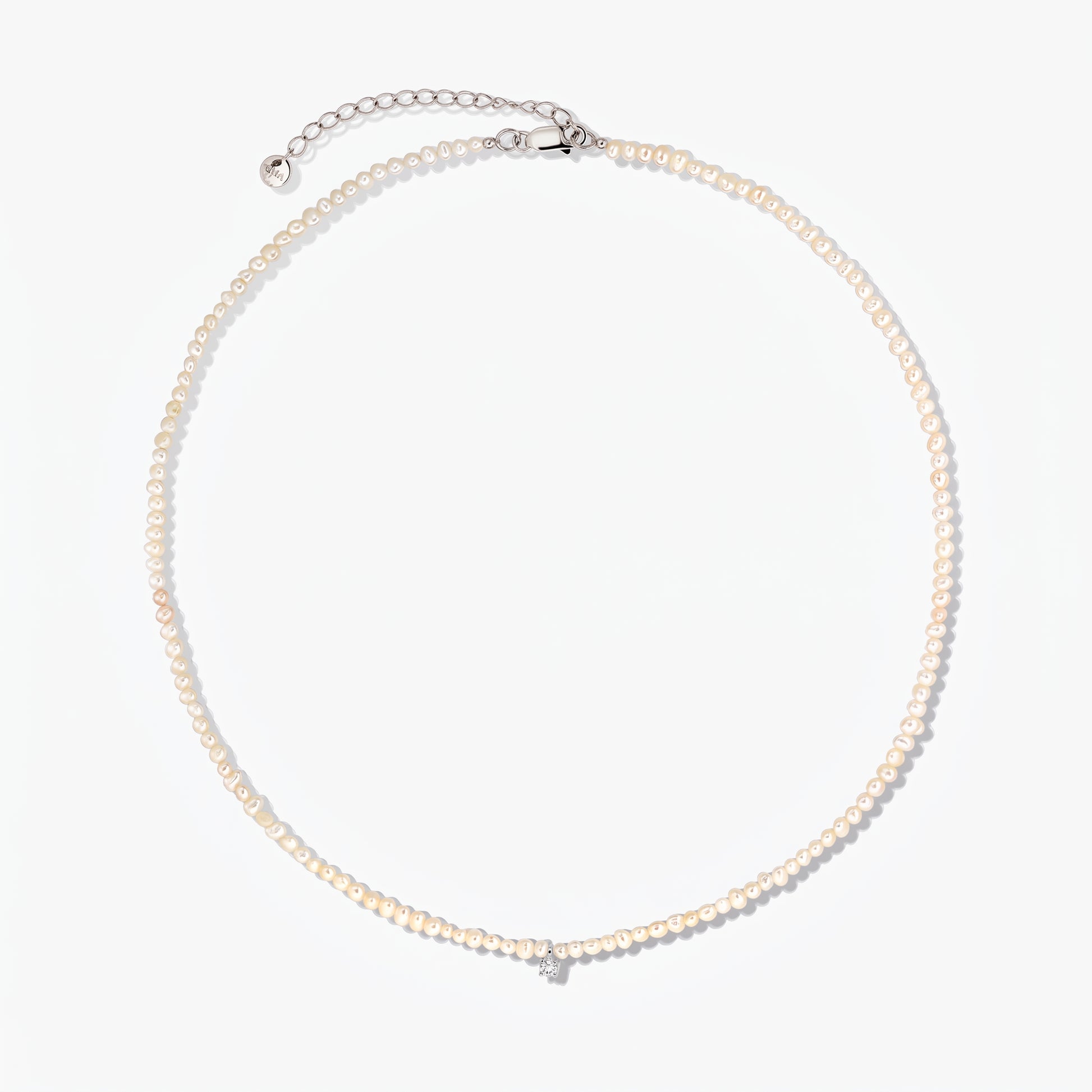 Fairy silver necklace with small cultured pearls and an adjustable extender chain, photographed on a white background.