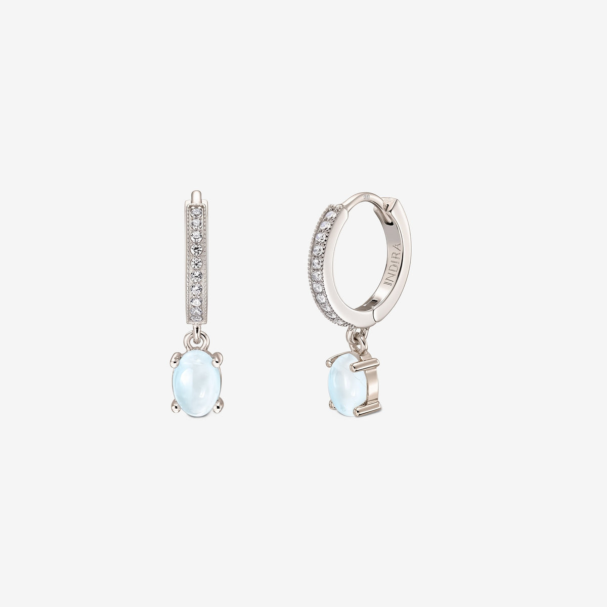 Pair of sterling silver huggie hoop earrings with pavé fronts and oval cabochon moonstone drops on a white background.
