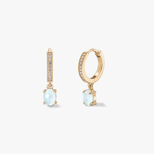 Indira Golden Gem Huggies silver earrings with oval moonstone drops and pavé-set hoops, displayed against a white background in front and side views.