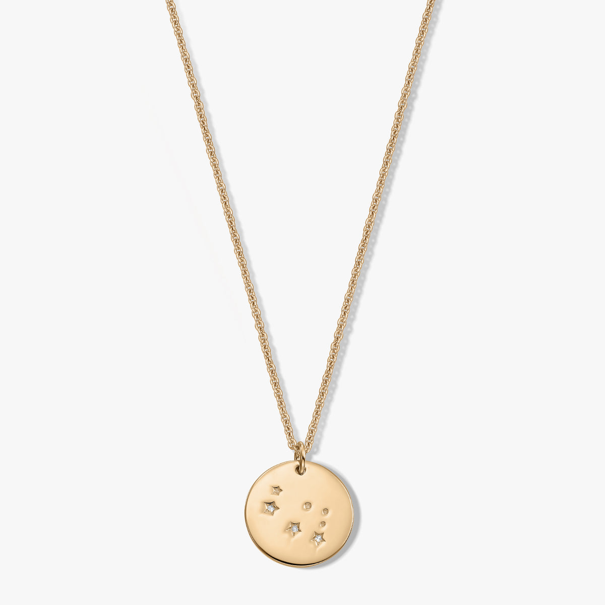 Delicate sterling silver Gemini zodiac disc pendant necklace set with a white sapphire on a white background.