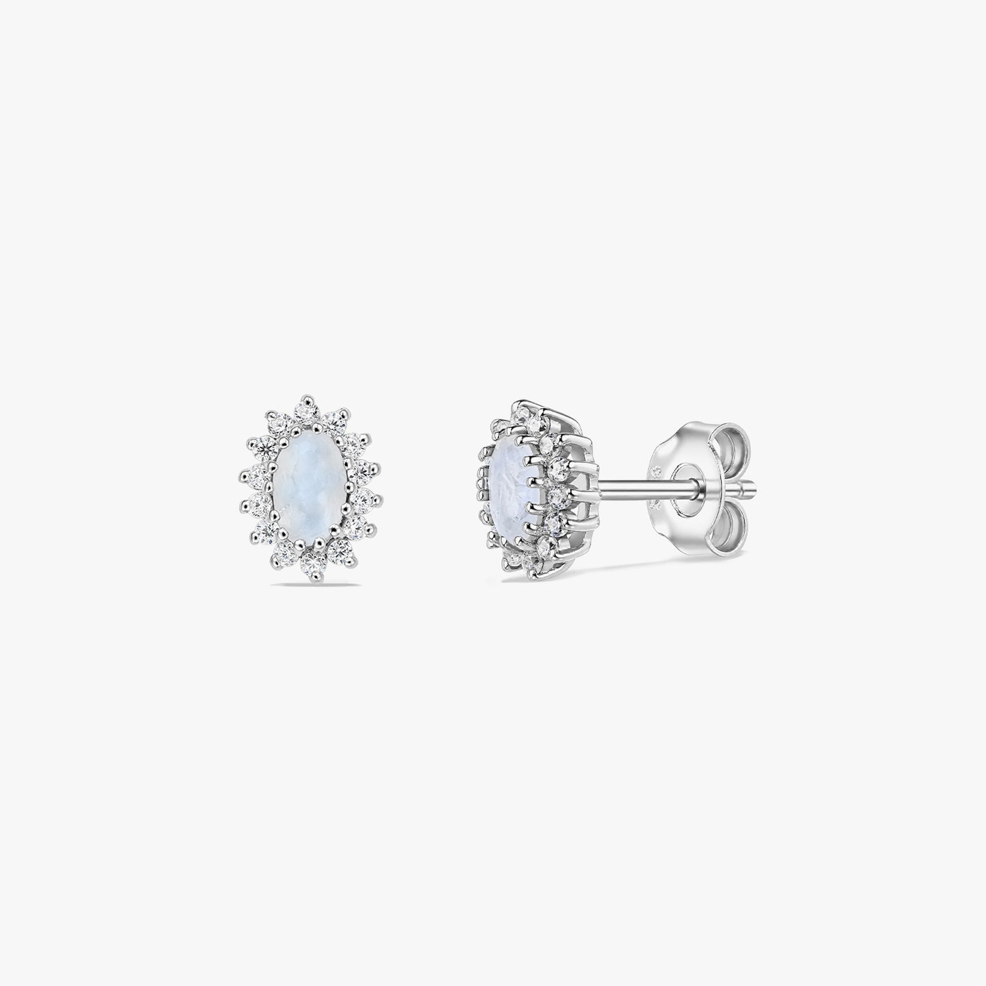 Pair of sterling silver moonstone halo stud earrings on a white background, shown in front and side views with oval cabochon centers and butterfly backs.