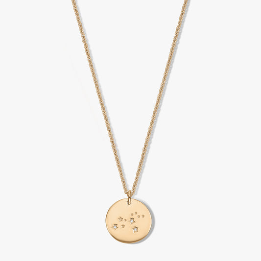 Golden Zodiac – Leo round disc pendant necklace with small star and dot accents set with white sapphires on a delicate chain, isolated on a white background.